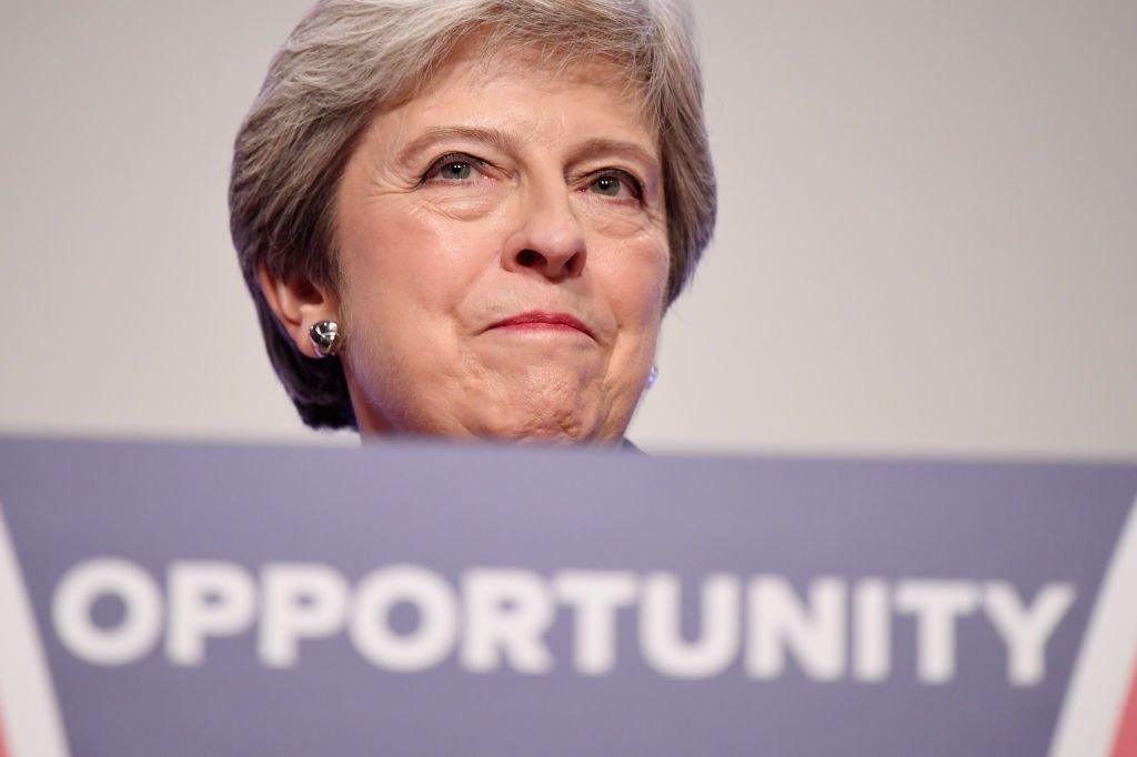 Theresa May standing behind conference podium