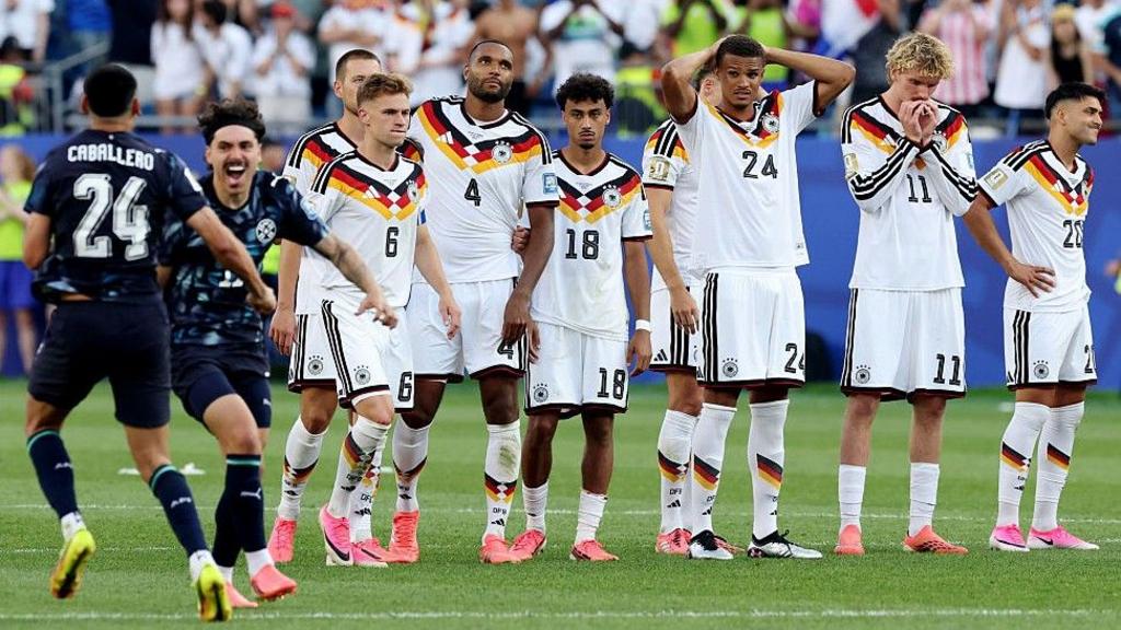Paraguay celebrate and Germany players look dejected as the winning penalty is scored