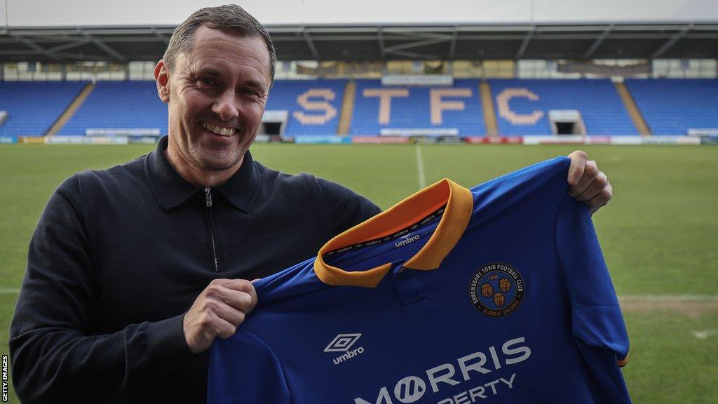 Shrewsbury Town head coach Paul Hurst posing with the club shirt