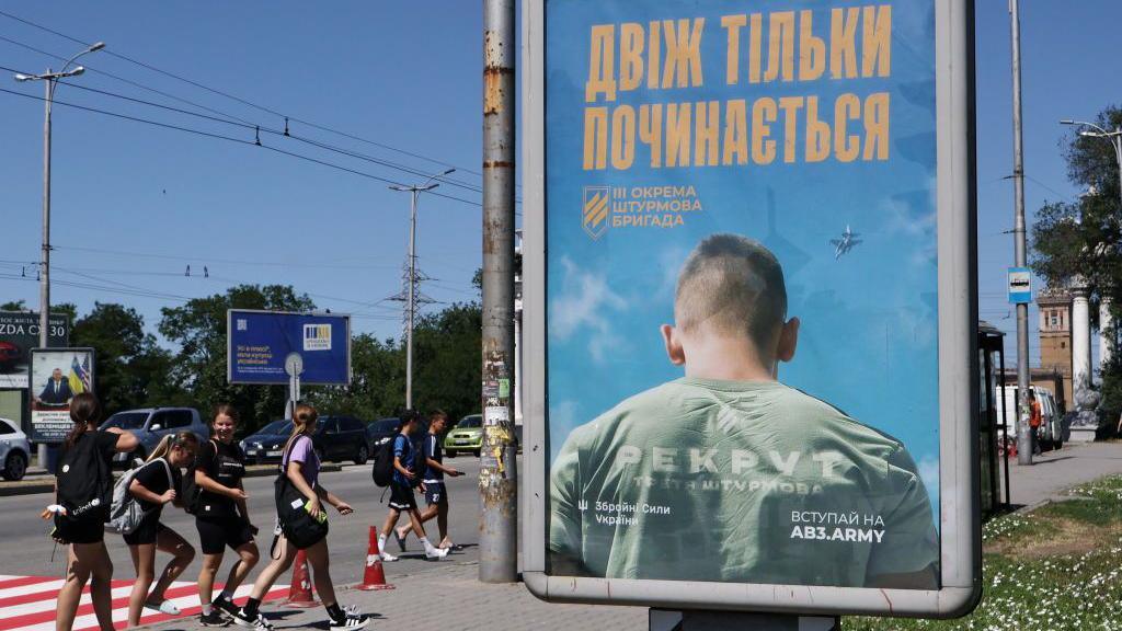 A recruitment poster in central Zaporizhzhia calls on men to sign up to fight