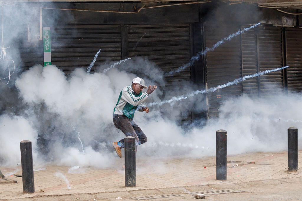 A protester runs to get away from a detonating tear gas canister during a demonstration against the government in Nairobi, Kenya, on 8 August 2024