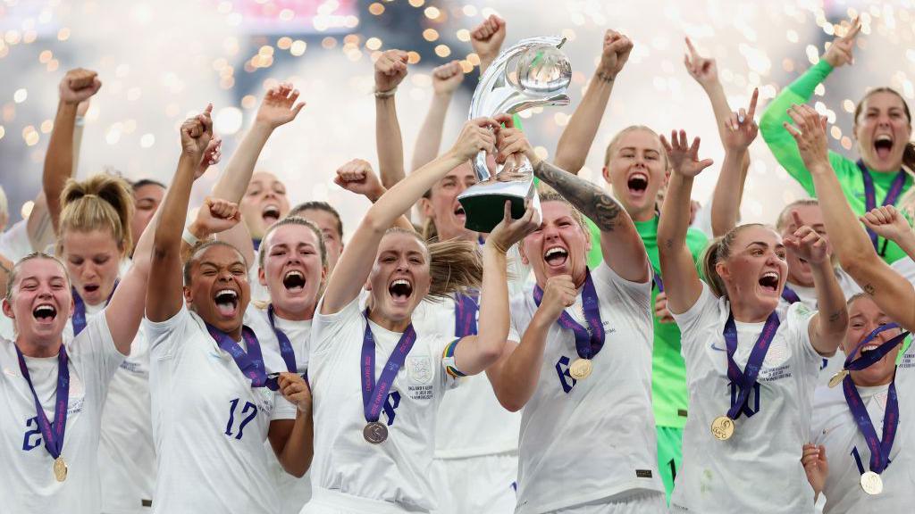 Millie Bright and the rest of the Lionesses lifting the Euro 2022 trophy
