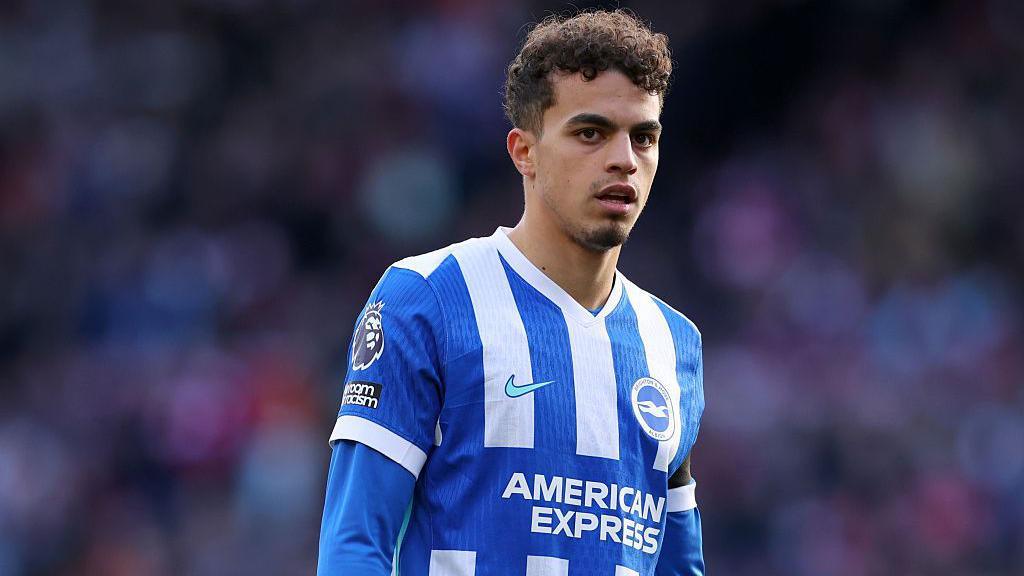 Yasin Ayari wearing a blue and white striped Brighton shirt