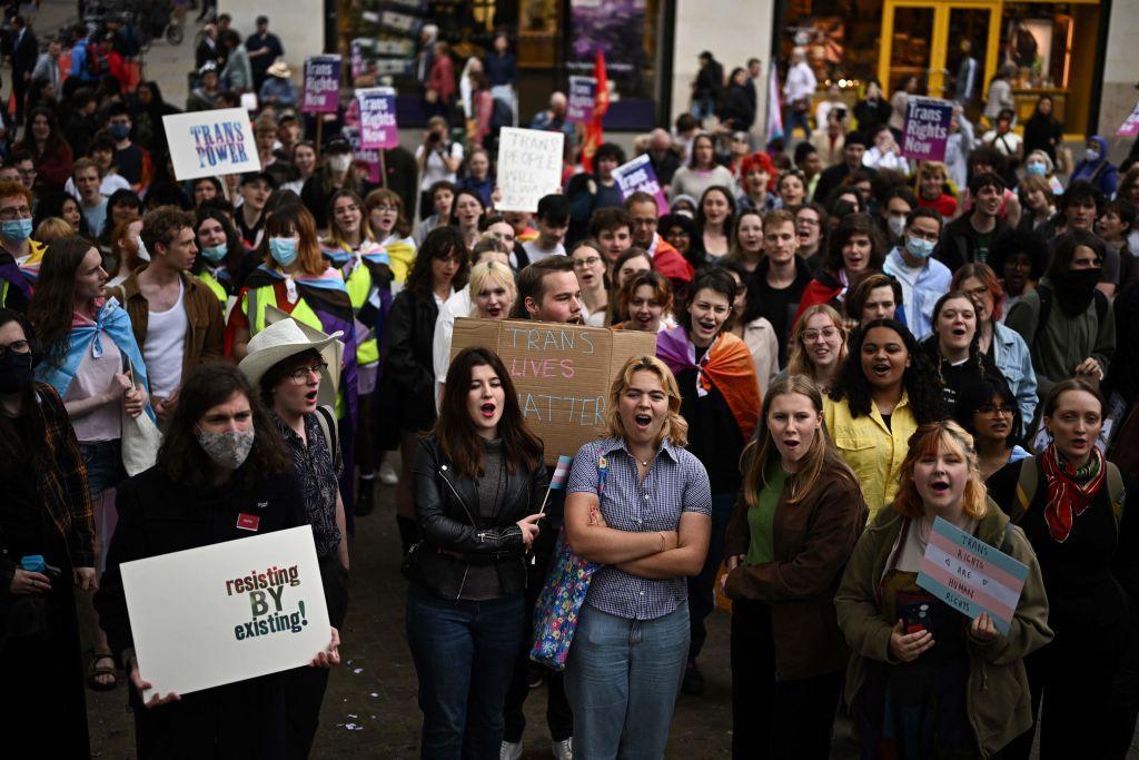 Group of protestors outside a university hall with signs and banners