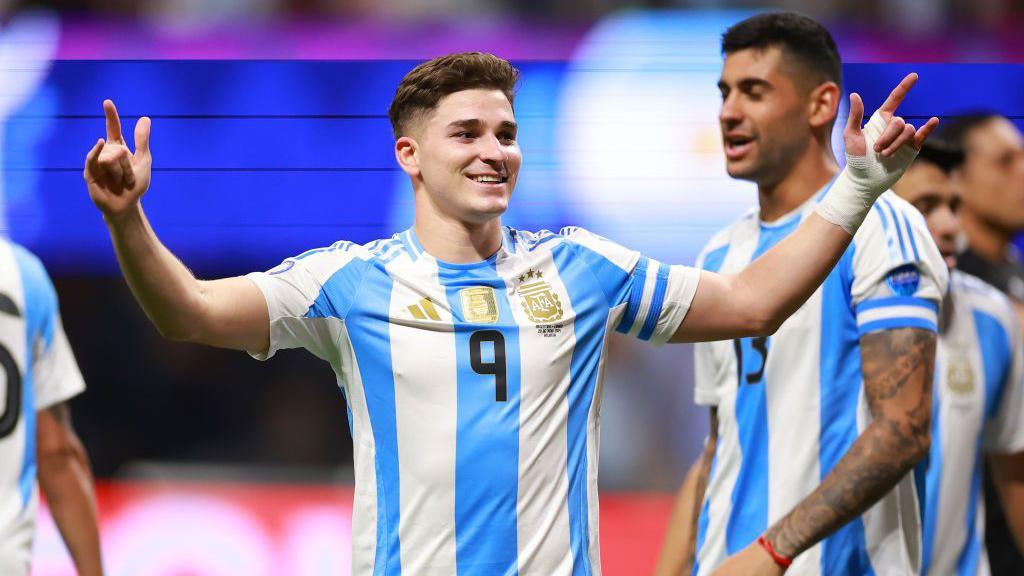 Julian Alvarez holds out his arms in celebration after scoring against Canada