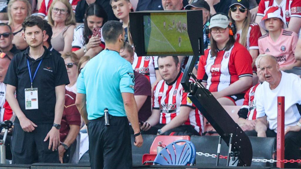 Andy Madley looks at a VAR screen