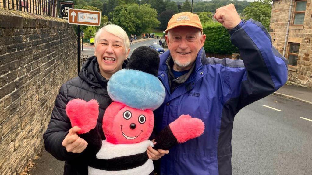 Denise and Terry Robinson with mascot Bertie watching the Tour of Britain in Oughtibridge