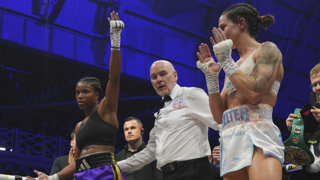 Caroline Dubois has her hand raised as Terri Harper claps
