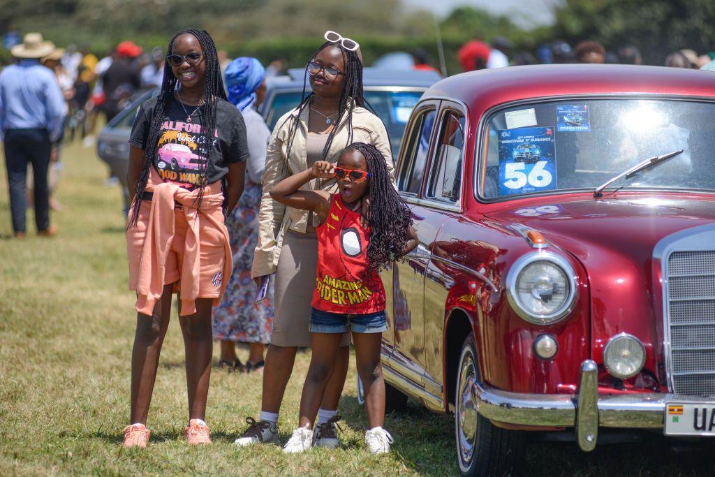 Girls pose for a photo next to a red car - Sunday 29 September 2024