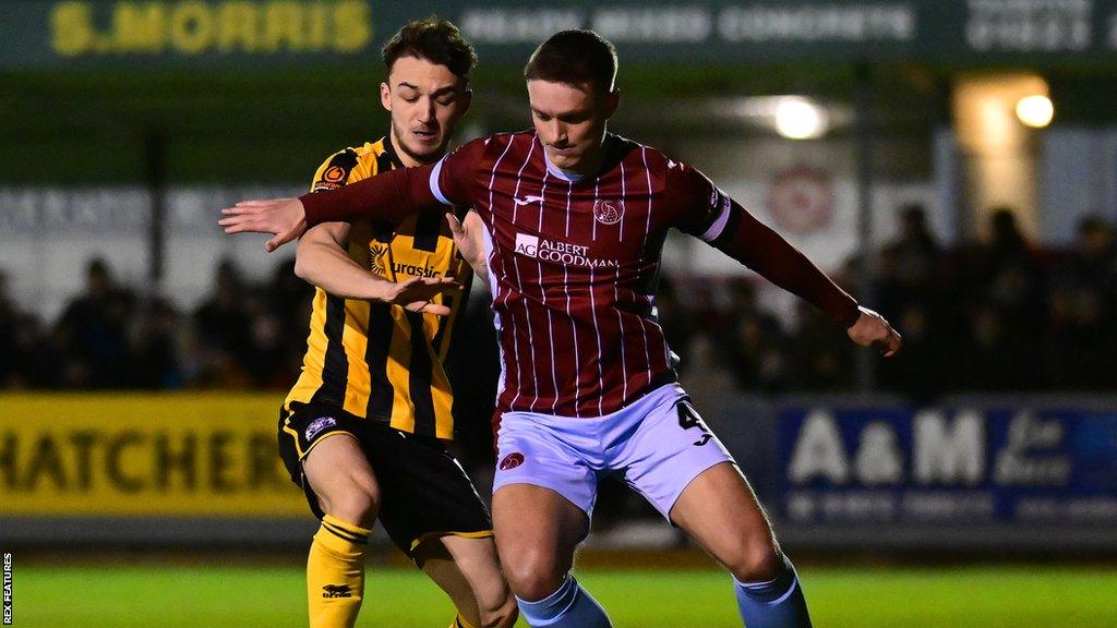 Taunton captain Nick Grimes is challenged for the ball by a Yeovil player