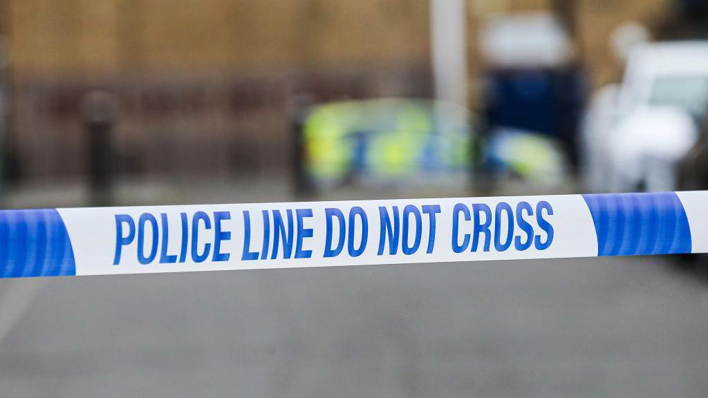 A stock image of blue-and-white police tape at an incident.