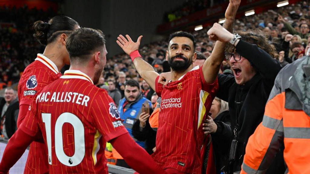 Mohamed Salah celebrates his goal against Manchester City by sitting next to a fan