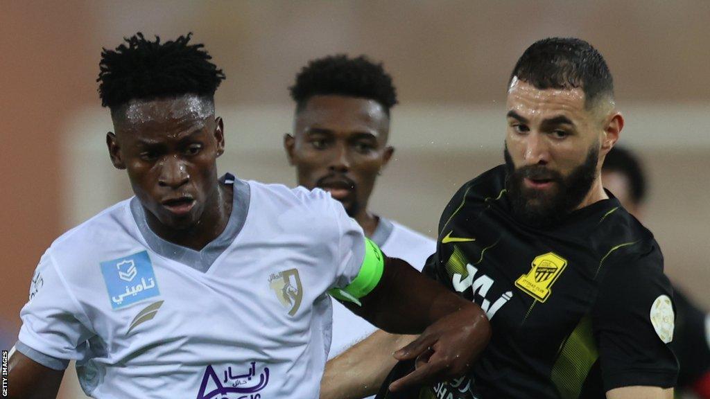 Karim Benzema of Al Ittihad battles with Alfa Semedo of Al-Tai during the Saudi Pro League football match between Al Ittihad and Al-Tai at Prince Abdullah Al Faisal Stadium