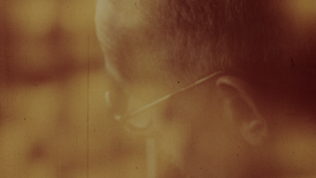 A creative blurry image of a man in glasses looking down towards the ground