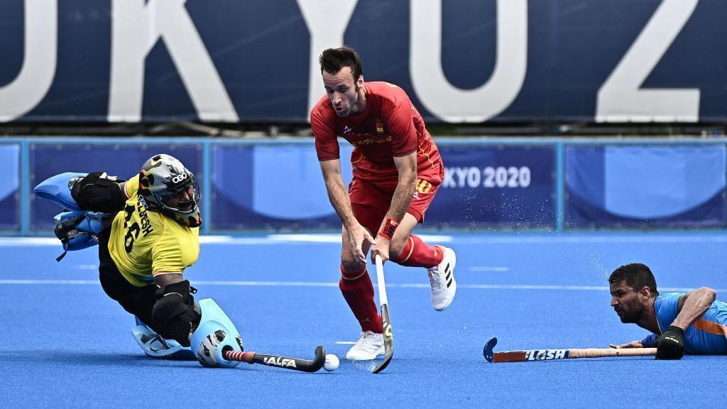 Spain's David Alegre (C) dribbles the ball between India's goalkeeper Sreejesh Parattu Raveendran (L) and player Harmanpreet Singh during their men's pool A match of the Tokyo 2020 Olympic Games field hockey competition, at the Oi Hockey Stadium in Tokyo on July 27, 2021. (Photo by JEFF PACHOUD / AFP) (Photo by JEFF PACHOUD/AFP via Getty Images)