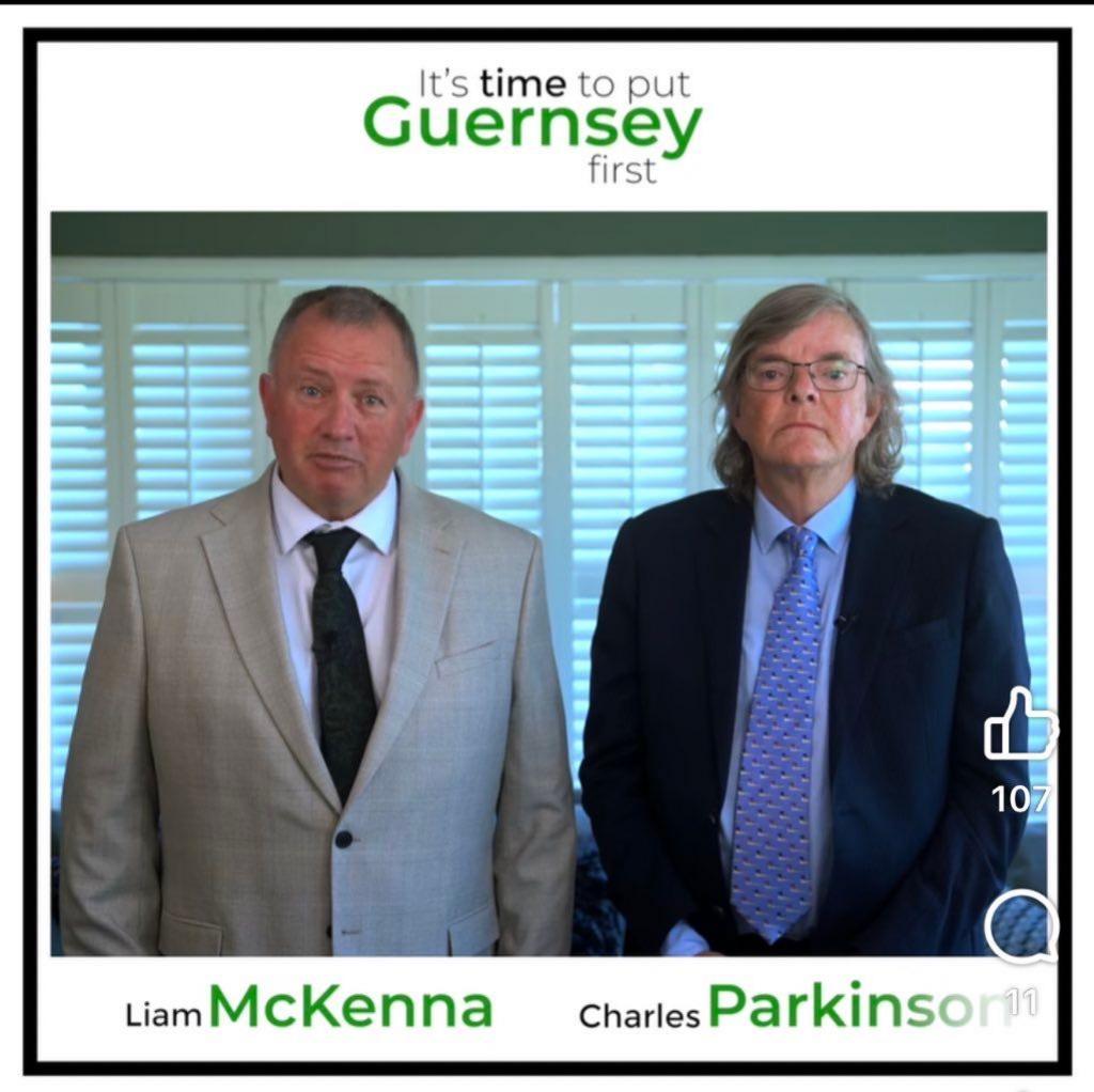 A man with a grey suit and a black tie, wearing a white shirt looking towards the camera standing next to a man with long grey hair, wearing glasses, a blue patterned tie and a navy blue suit. 

The names Deputy Liam McKenna and Charles Parkinson are across the bottom. 