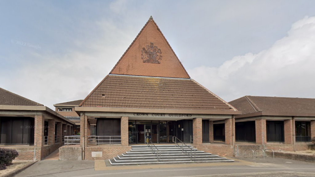 A Google Street image of the outside of Guildford Crown Court, which is a red bricked-building with a high roof. 