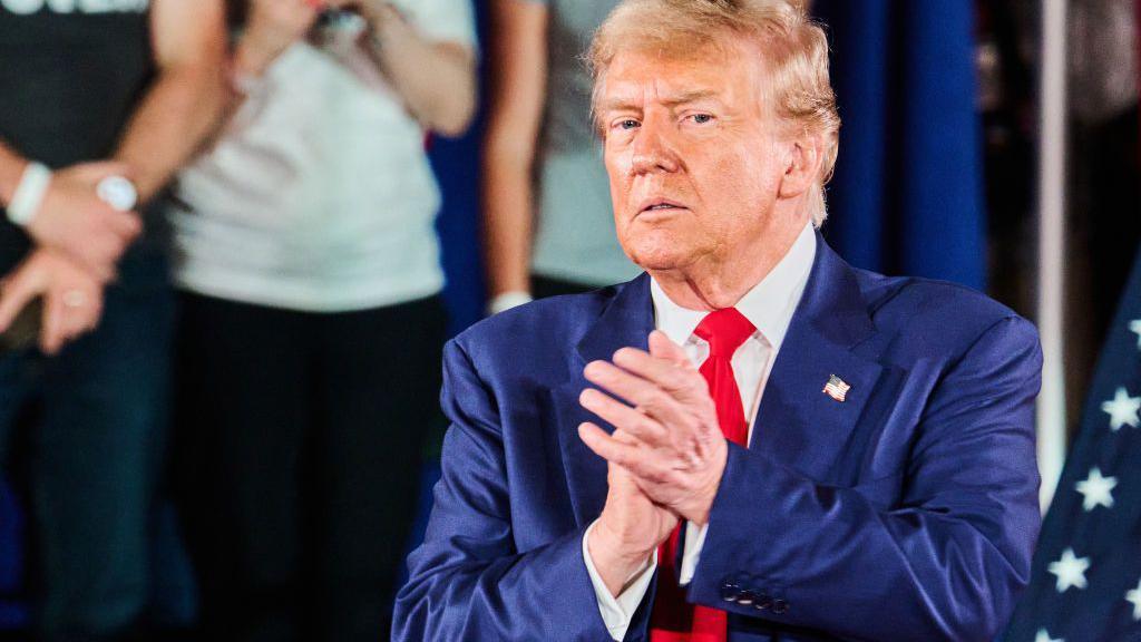 Trump with his hands pressed together at a rally on 1 May in Wisconsin