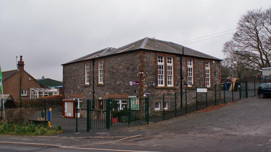 An old stone school building in Dumfries and Galloway on a grey day