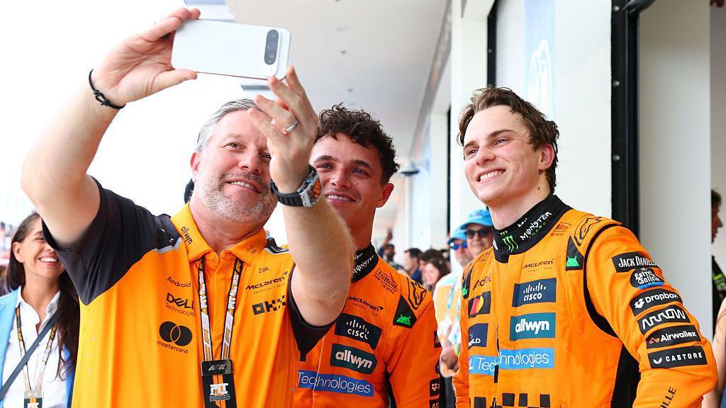 McLaren CEO Zak Brown takes a selfie with drivers Lando Norris and Oscar Piastri after the 2025 Miami Grand Prix