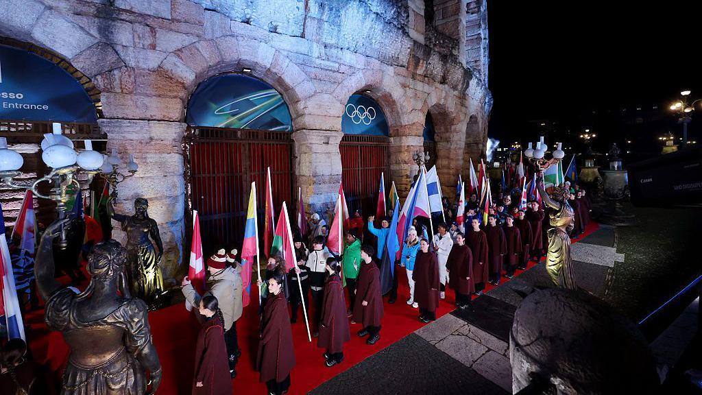 The flagbearers enter the arena