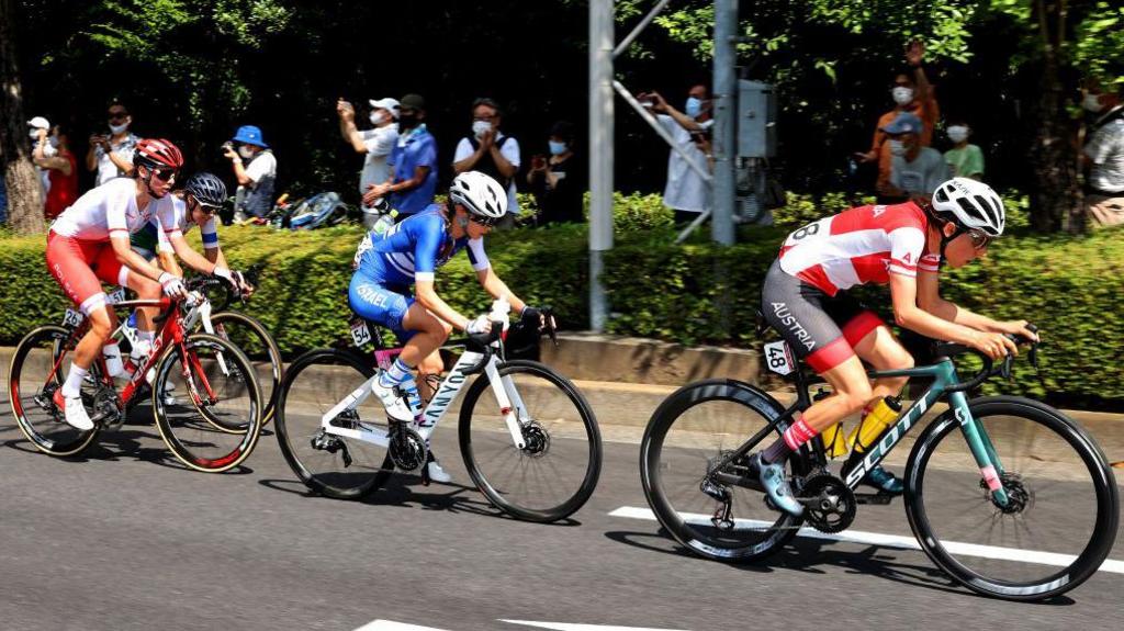 Cyclists, including eventual winner Anna Kiesenhofer, compete in the women's road race at Tokyo 2020