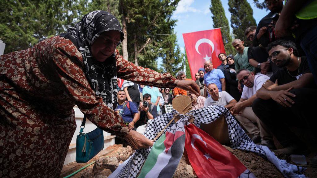 The body of Turkish American activist Aysenur Ezgi Eygi is buried in Didim Asri Cemetery as Turkish and Palestinian flags and keffiyehs are placed on Eygi's grave during the funeral ceremony in Didim distict, Aydin, Turkiye on September 14, 2024.