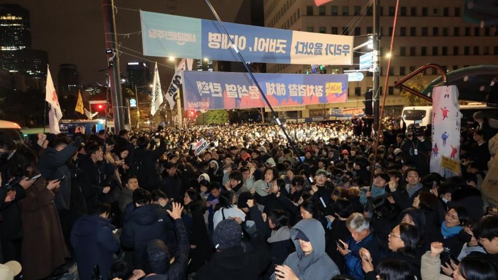 eople gather in front of the National Assembly in Seoul, South Korea, in the early hours of 04 December 2024, demanding the withdrawal of martial law