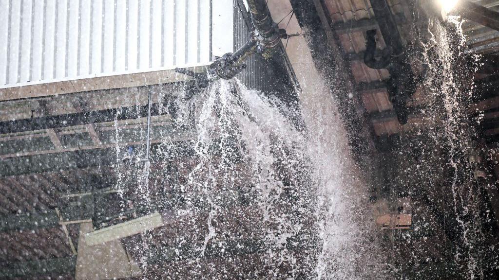 A detailed view as the drainage pipe in the roofs of the Sir Alex Ferguson Stand and East Stand leaks and pours onto the seats at Old Trafford