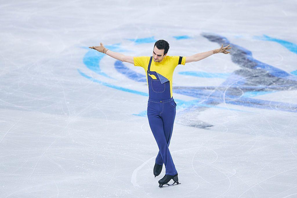 Tomas-Llorenc Guarino Sabate of Spain competes in figure skating wearing his yellow top and blue dungarees. 