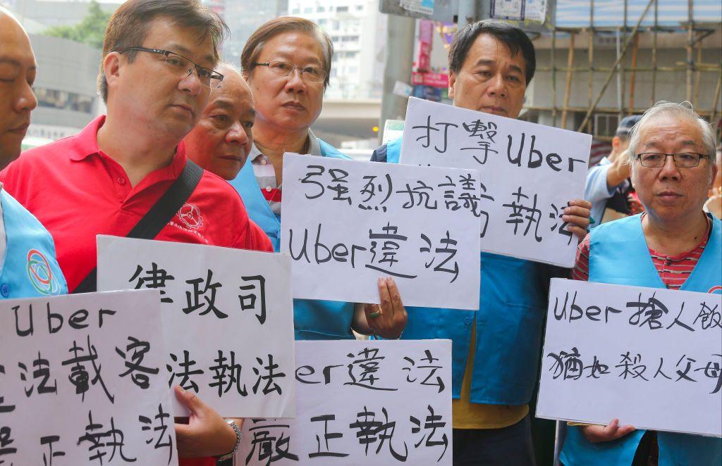 Hong Kong taxi drivers hold a protest outside the Uber headquarters in Causeway Bay