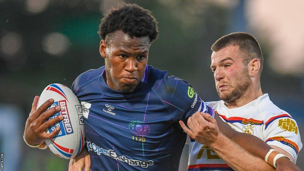 Wigan Warriors' Junior Nsemba tussles with Max Jowitt of Wakefield Trinity