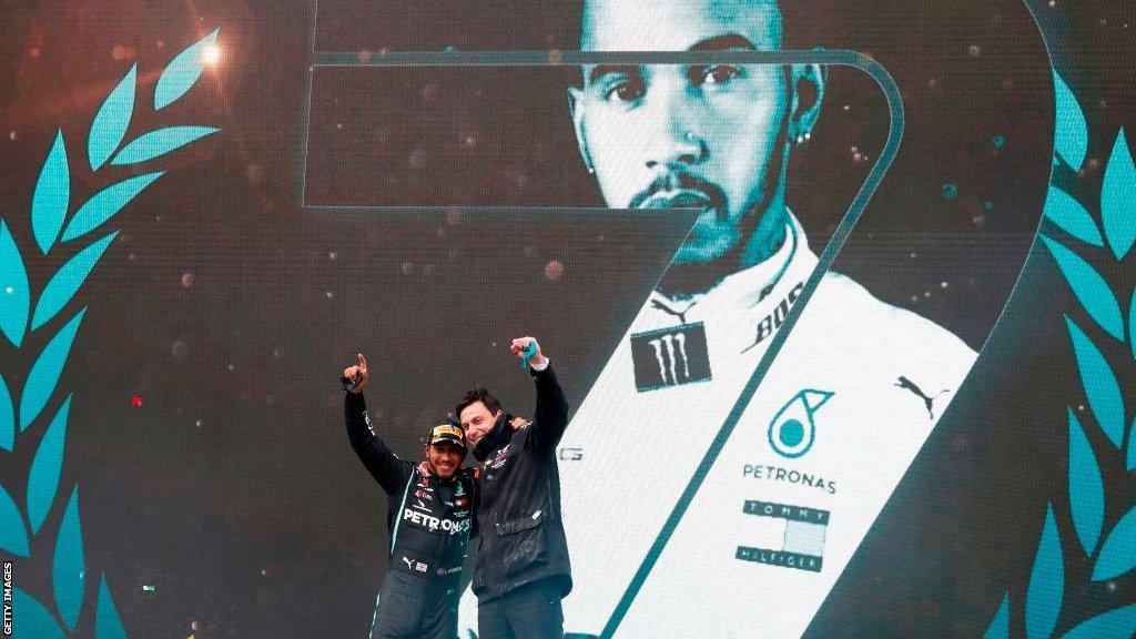 Lewis Hamilton and Mercedes Team Principal Toto Wolff celebrate on the podium