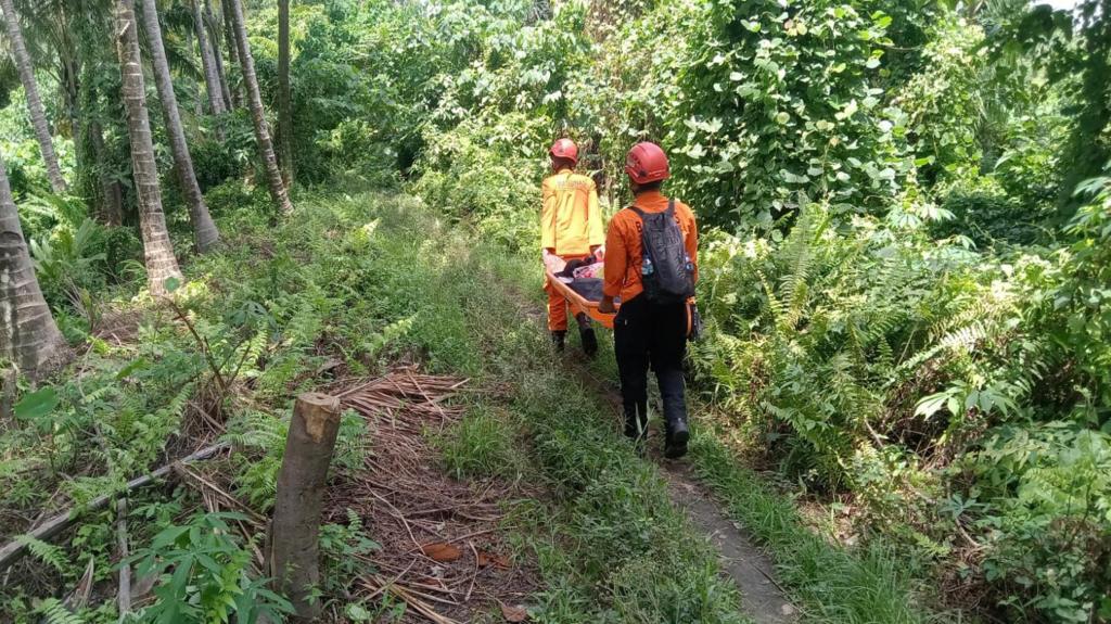 Two Indonesia rescuers wearing orange on their way to Mount Dukono where 20 hikers have gone missing