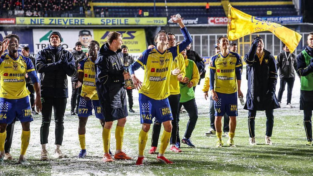 Sint-Truiden players celebrate after the final whistle after securing a victory against Zulte Waregem