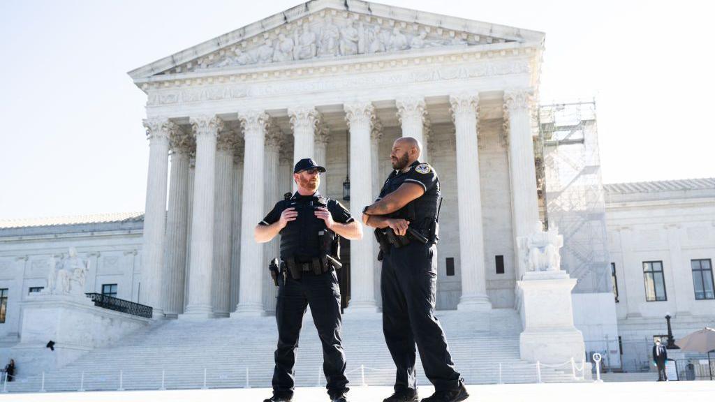 Security officers stand outside the US Supreme Court on the first day of a new term in Washington DC. The officers wear head-to-toe black clothing.