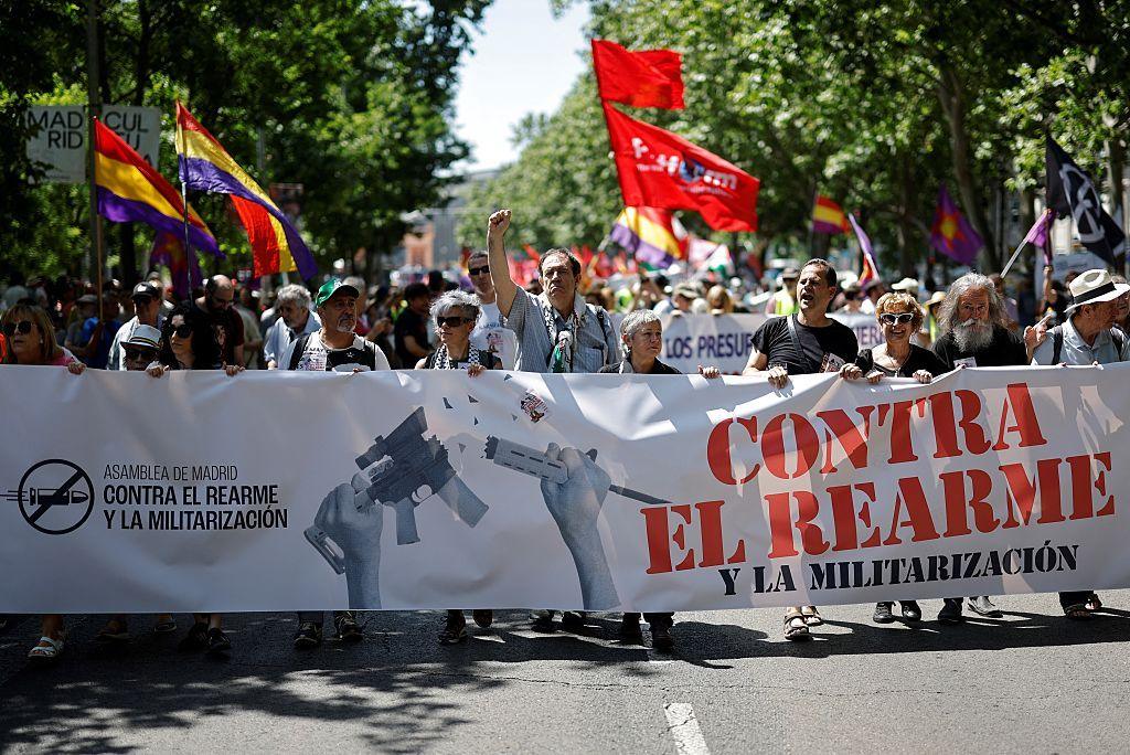 Protesters hold a banner reading 'against rearmament and militarisation' during a demonstration for peace and against the rearmament of Spain in Madrid on June 7, 2025