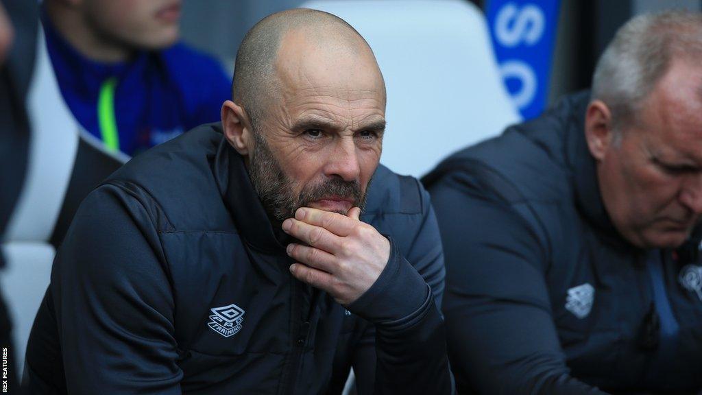 Derby County boss Paul Warne looks on from the dug out during a game