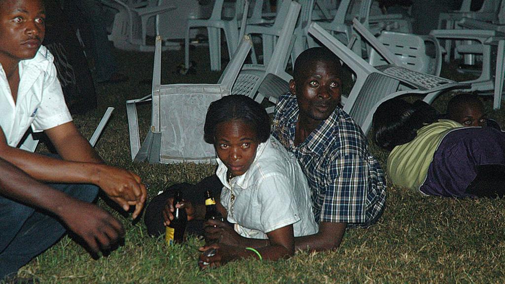 Survivors are seen at an Ethiopian-owned restaurant in the Kabalagala area of Kampala late on July 11, 2010 moments after twin bomb blasts tore through crowds of football fans watching the World Cup final, killing 64 people, including an American, and wounding scores others