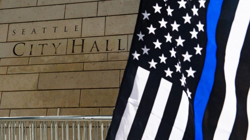 A pro-police flag flies near the Seattle City Hall