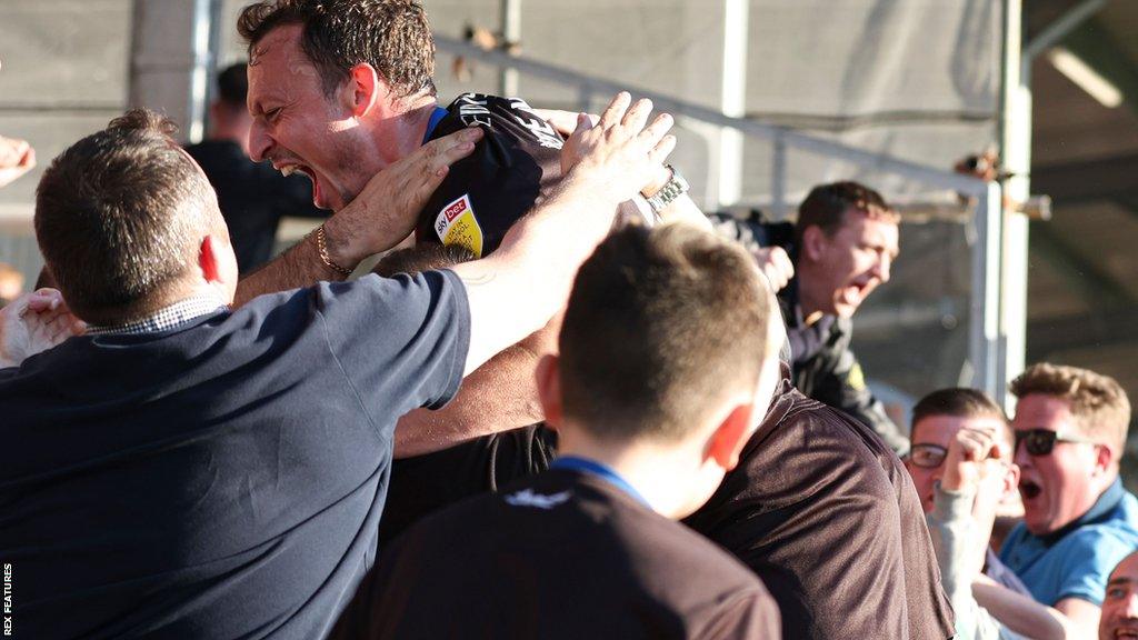 Striker Kristian Dennis celebrates with Carlisle fans at Holker Street