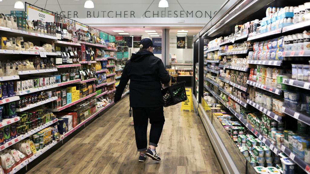 A shopper seen walking between the aisles at a supermarket in Kendal, UK