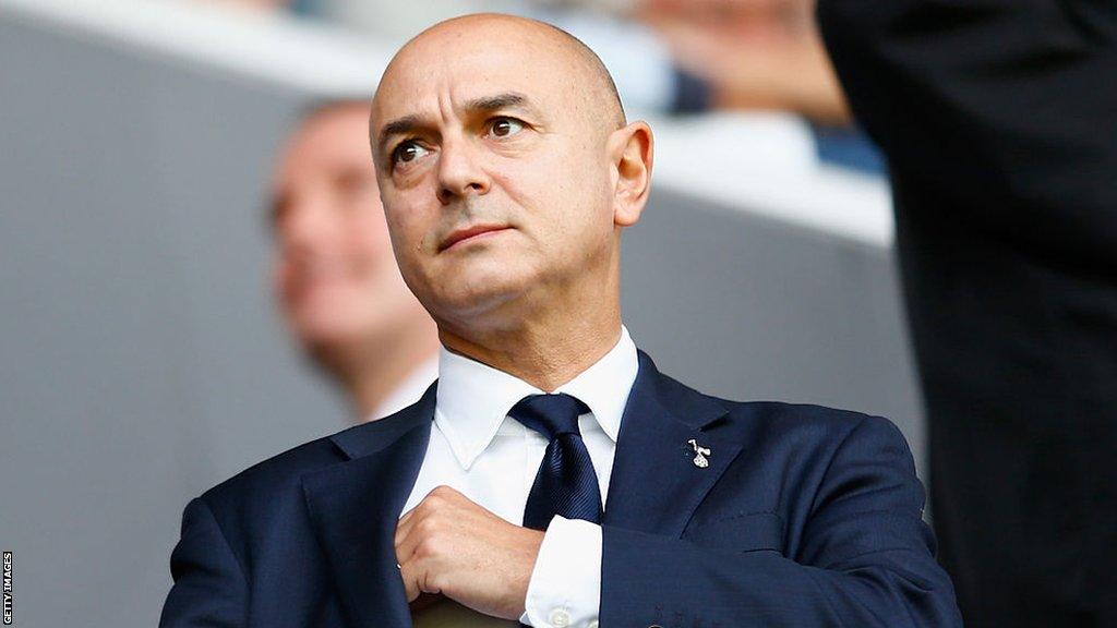 Daniel Levy wearing a suit and a Tottenham crest lapel badge