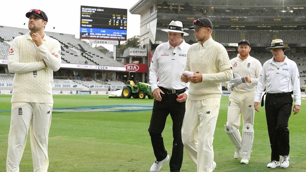 Players walk off as rain falls