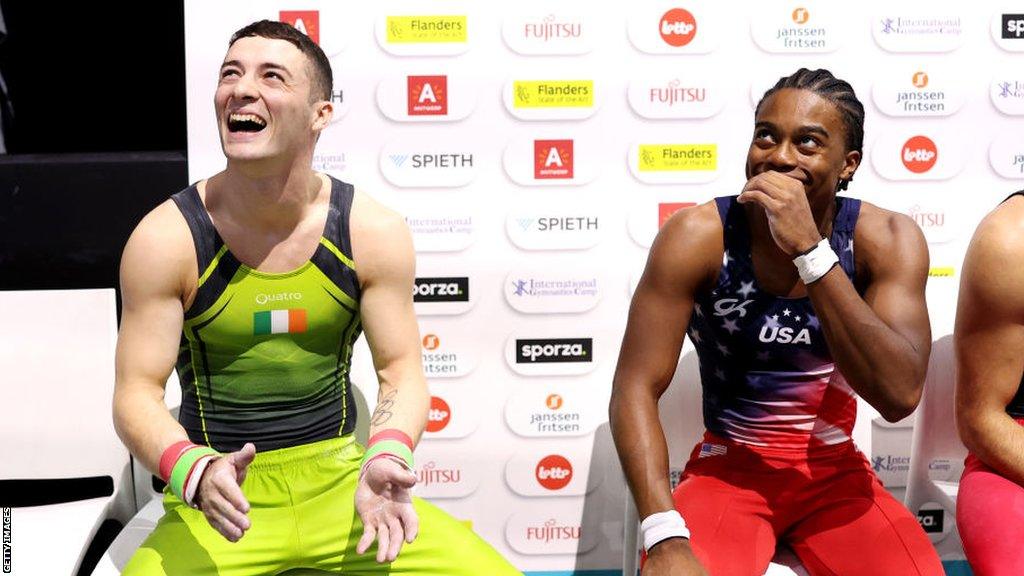 Rhys McClenaghan reacts after realising he has won the gold medal in Antwerp as silver medallist Khoi Young looks on