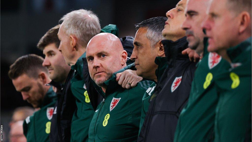 Robert Page (fourth left) surrounded by his staff during the anthem