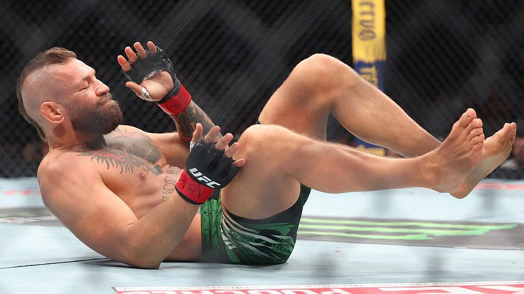 Conor McGregor lies on his back in the octagon