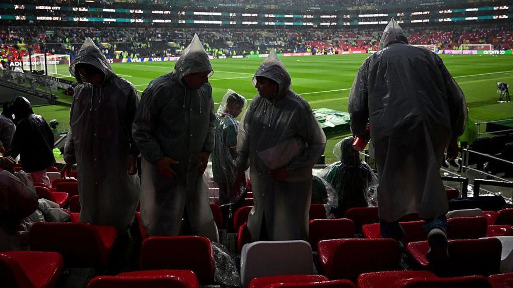 Fans wearing rain ponchos are seen in the stands ahead of the 2026 World Cup round of 32 football match between Mexico and Ecuador