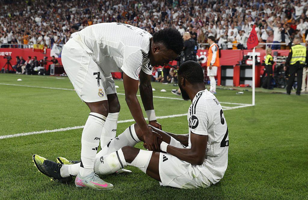 Antonio Rudiger on the floor being comforted by team-mate Vinicius Jr.