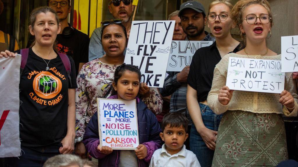 Protesters hold placards and chant slogans during the demonstration. Fossil Free London staged a protest outside the Department for Transport calling on the government not approve the expansion of London City Airport in July 2024.